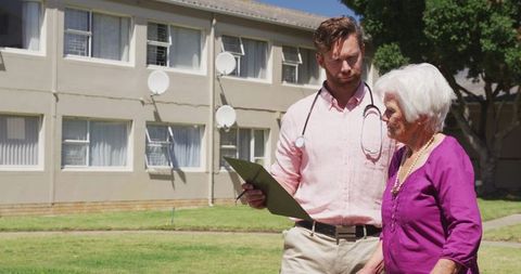 Caucasian doctor communicating with elderly patient outdoors