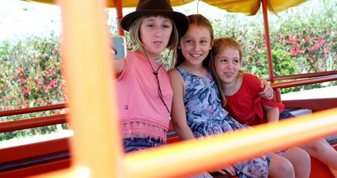 Young girls smiling happily on amusement park ride