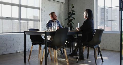 Business professionals discussing documents in modern office meeting room