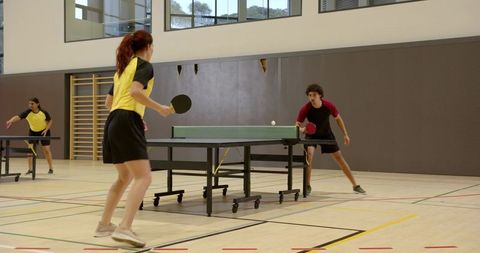 Energetic Table Tennis Match in Sports Hall with Teammates
