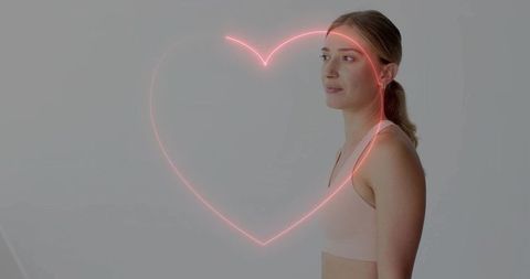 Female athlete standing in profile with neon pink heart overlay minimalist wellness concept