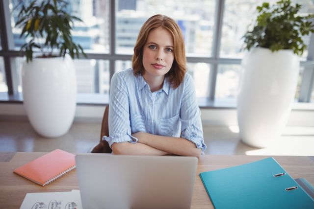 Portrait of confident executive sitting at desk in office