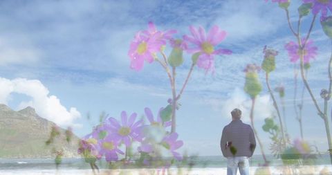 Standing man gazing at ocean with floral double exposure, serene coastal contemplation