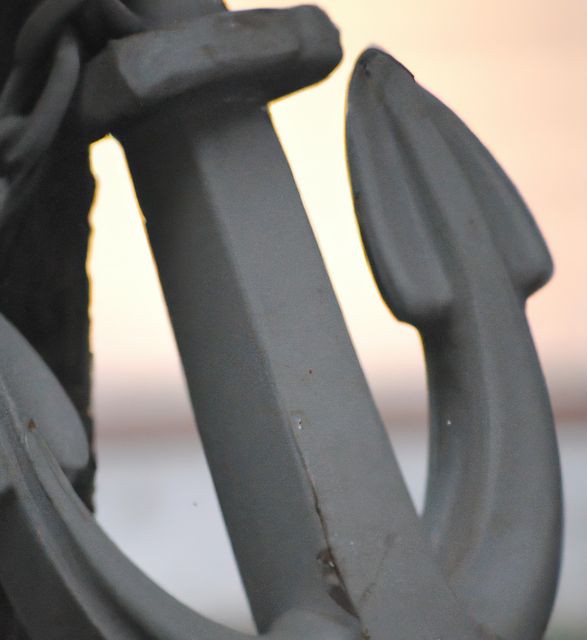 This closeup image of a metal boat anchor shows extensive details, suitable for use in marine or maritime themed blogs, articles, or presentations. Can be used to represent stability, security, and connection in varied contexts such as shipping industries, nautical products, and lifestyle imagery.