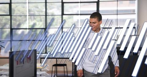 Business Analyst Walking Through Open-Plan Office With Holographic Bar Chart Visualization