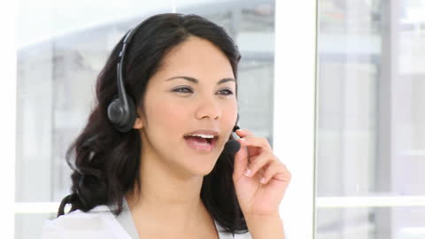 Smiling customer service representative using headset in modern office