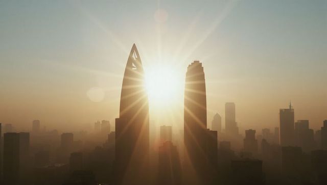 Sunrise Over Modern City Skyline Illuminating Skyscrapers with Lens Flare