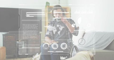 Man in wheelchair holding mug and reading open book with futuristic hud overlay at home