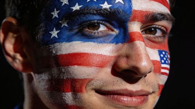 Young man with american flag face paint closeup patriotic headshot high-contrast studio
