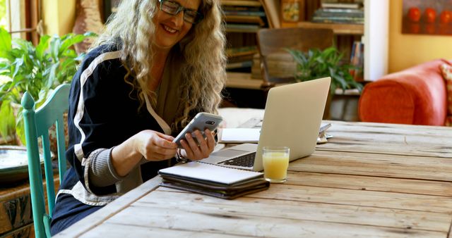 Smiling Woman Working from Home on Laptop and Phone - Download Free Stock Images Pikwizard.com