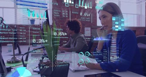 Diverse Professionals Analyzing Data with Digital Interfaces in Modern Office