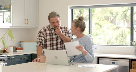 Senior Couple Reviewing Documents in Modern Kitchen