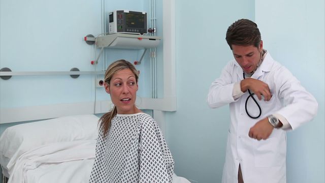 Doctor consulting patient in hospital ward, indicating a medical examination with a friendly interaction. Ideal for healthcare services, medical consultations, patient care adverts, hospital brochures, doctor-patient relationships, and health insurance marketing.