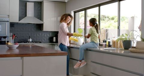 Biracial Mother and Daughter Cleaning Together in Modern Kitchen - Download Free Stock Images Pikwizard.com