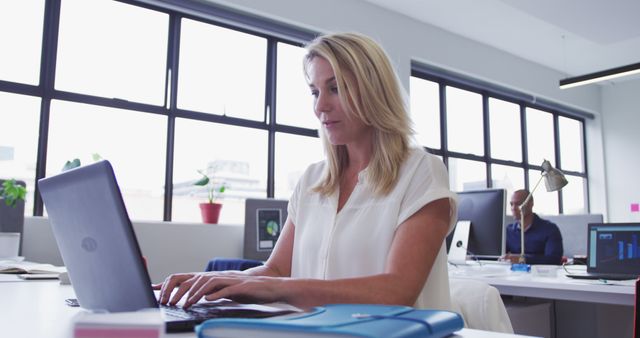 Focused professional woman working in modern office setting - Download Free Stock Images Pikwizard.com