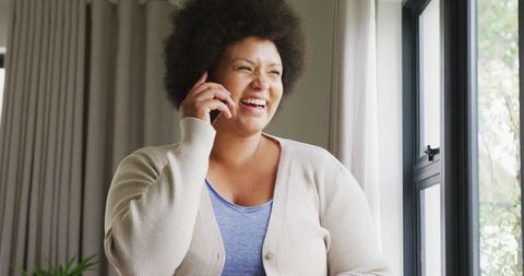 Happy Woman Talking on Smartphone Affectionately Near Window - Download Free Stock Images Pikwizard.com