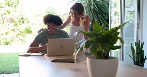 Couple Collaborating at Home on Laptop Surrounded by Nature