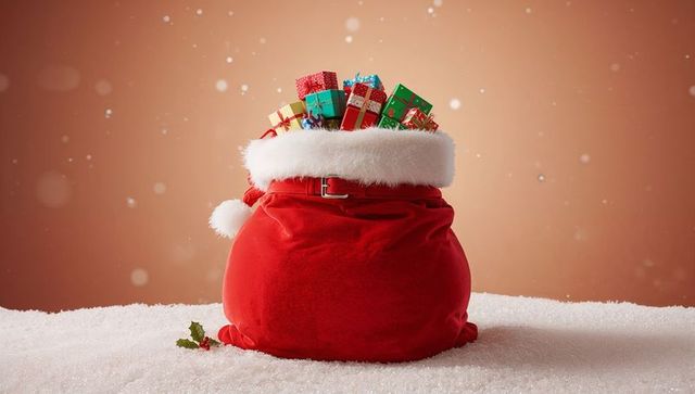 Santa sack overflowing with colorful wrapped gifts on sparkling snow for holiday cheer