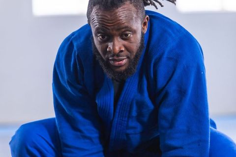Martial Artist Practicing in Blue Gi on Padded Mat