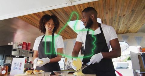 Smiling food stall team slicing cheese and assembling rolls at outdoor market kiosk