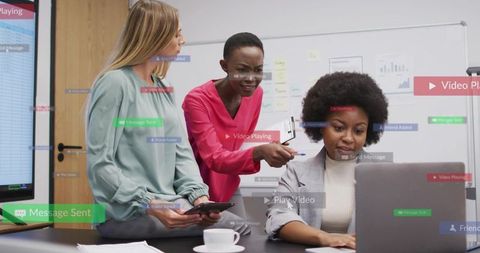 Three professional women collaborating over laptop in modern office meeting room