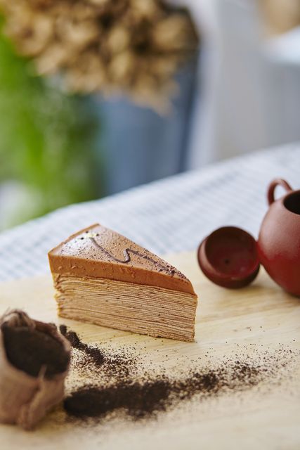 Close-up shot of a beautifully layered mille-feuille pastry adorned with a chocolate dusting. Ideal for food blogs, dessert menus, recipe books, culinary magazines, gourmet cuisine posters and advertisements showcasing delicious sweets.