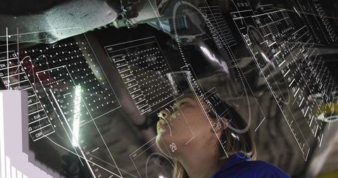 Female aircraft technician inspecting landing gear using AR overlays and holographic data in hangar