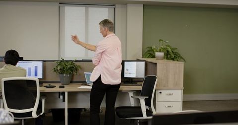 Office Team Engaged in Data Presentation and Discussion