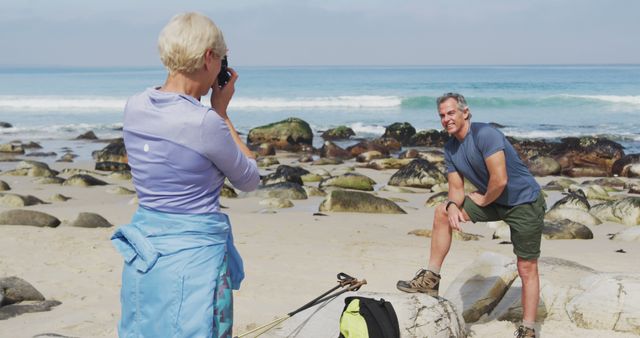 Senior couple captures beachside moments during a relaxing seaside adventure. Ideal for travel brochures, retirement lifestyle promotions, outdoor activity advertising, and senior health and wellness content.