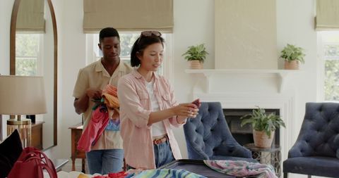 Couple Packing Luggage in Cozy Bedroom for Special Event Preparation