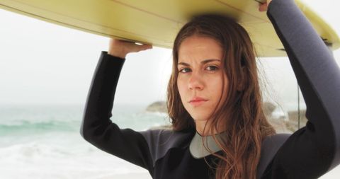 Confident Female Surfer Carries Board at Ocean Shoreline - Download Free Stock Images Pikwizard.com