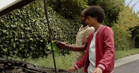 Father and Son Bonding While Inspecting Car Engine in Garden