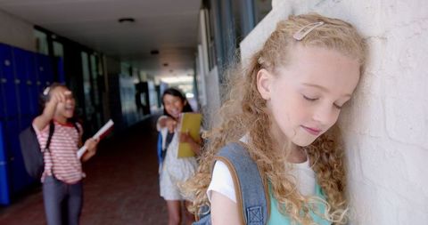 Sad Girl Leaning on Wall as Students Tease Her in School Hallway - Download Free Stock Images Pikwizard.com
