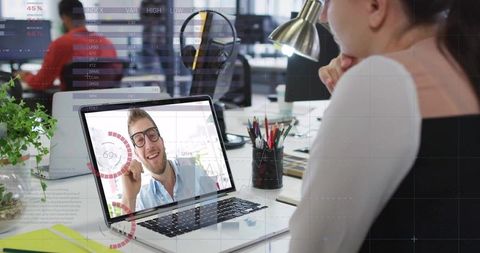 Businesswoman engaging in video conferencing at modern office desk