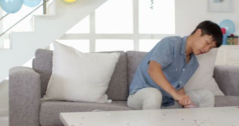 Asian man arranging balloons for celebration at home