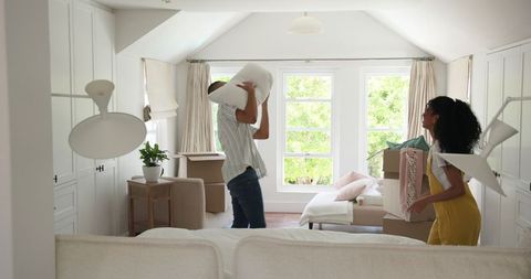 Diverse couple unpacking in bright living room
