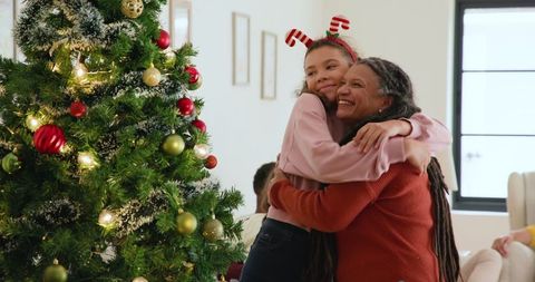 Multigenerational Family Embrace by Christmas Tree Holiday Joy