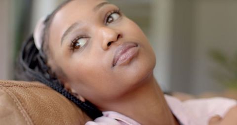 Pensive Young Woman with Braids Relaxing at Home