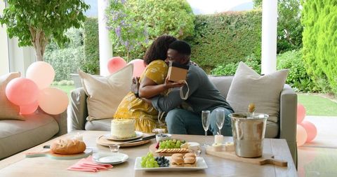 Mature Couple Embracing at Birthday Celebration with Gift Exchange