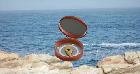 Hovering open amber compact with geometric gold jewel above rocky coastline seascape