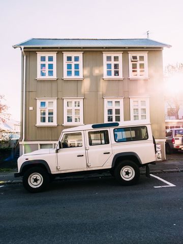 Classic land rover in front of rustic icelandic building