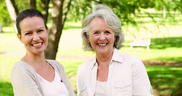 Mother and adult daughter laughing and chatting in the park on a sunny day - Download Free Stock Photos Pikwizard.com