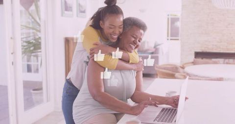 Loving Moment Between Mother and Daughter at Home with Laptop