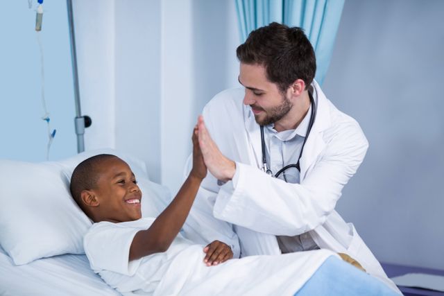 Doctor and patient giving high five in hospital