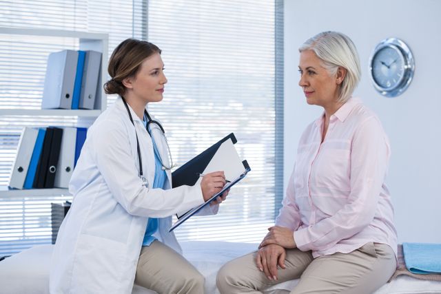 Medical professional consulting senior patient in modern medical office. Ideal for healthcare, medical services, patient care, and health checkup concepts. Useful for articles, brochures, and websites related to healthcare and medical advice.