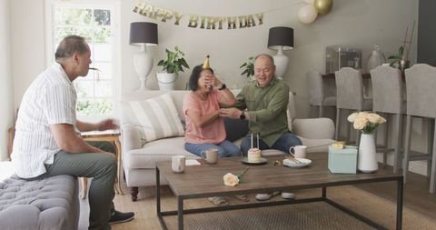 Senior Friends Celebrating Birthday at Home with Cake and Joyous Laughter