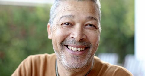 Middle-Aged Man Smiling Outdoors in Relaxed Setting