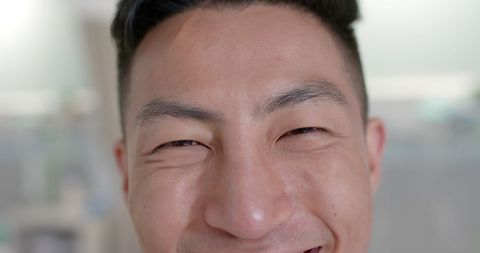 Smiling Asian Doctor in Hospital Setting, Close-Up Portrait