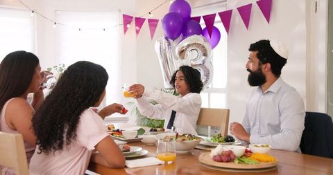 Family Celebrating a Bar Mitzvah at Home with Food and Speeches