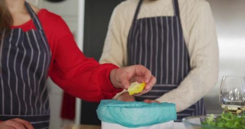 Couple preparing meal in modern kitchen with aprons